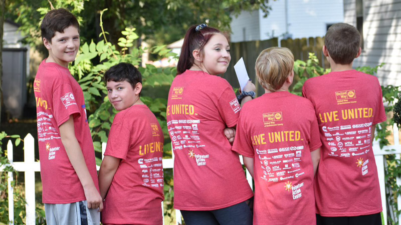 Outdoor photo of a group of kids wearing red Live United shirts